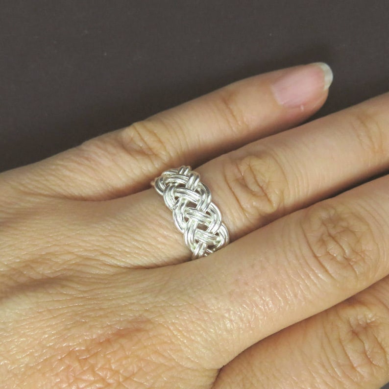 May include: A silver braided ring with a woven design.