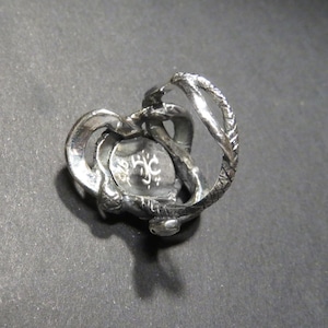 May include: Silver ring with a detailed design of a snake wrapping around the band. The ring is marked with the letters "J.C."