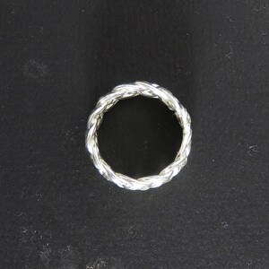 May include: A silver ring with a braided design.