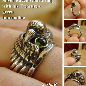 May include: A silver ring featuring a raven guarding a green tourmaline gemstone. The ring is made of multiple bands and has a textured finish.