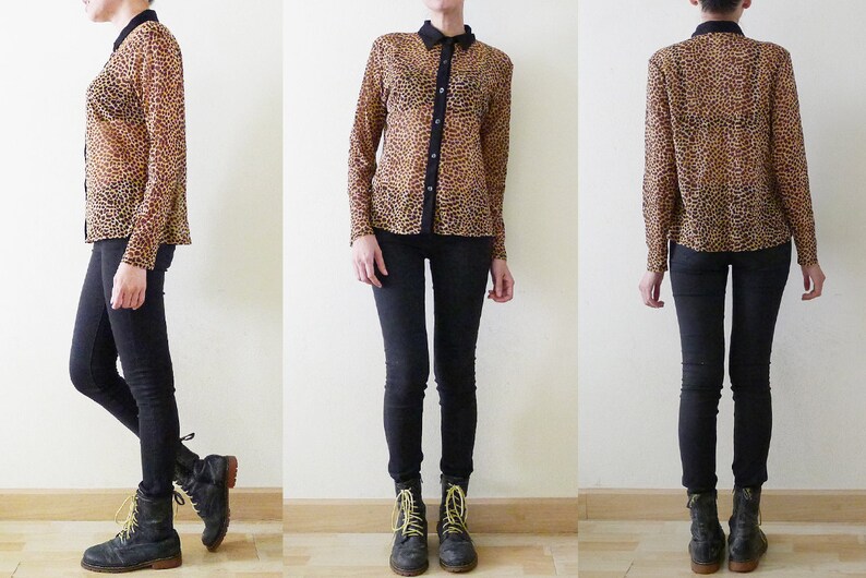 Op de afbeelding: Een doorschijnend overhemd met luipaardprint, een zwarte kraag en zwarte knopen. Het overhemd wordt gedragen met een zwarte skinny jeans en zwarte en gele veterschoenen.