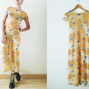 May include: A yellow maxi dress with a blue floral print. The dress has short sleeves and a scoop neck.