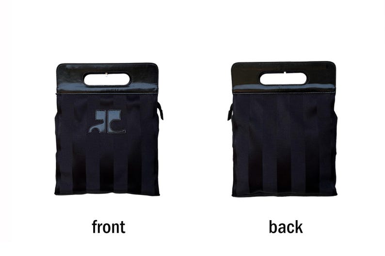 May include: Black tote bag with a rectangular handle and a dark, glossy finish. The front of the bag features a logo, and the back has vertical stripes. The bag is designed with a structured shape and a sleek, modern aesthetic.