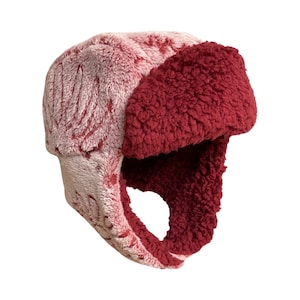 May include: A red and white faux fur trapper hat with a fold-down ear flap.