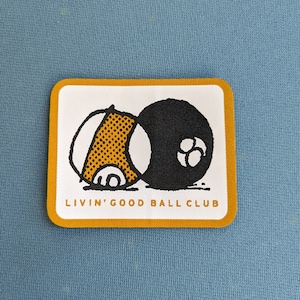 May include: A yellow and white patch with a black and white illustration of two balls. The text "Livin' Good Ball Club" is printed in black below the illustration.