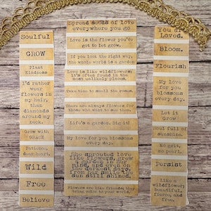Puede incluir: Un collage de tiras de papel con citas inspiradoras y frases como "Soulful", "Grow" y "Believe". Las tiras est&aacute;n dispuestas sobre una superficie de madera, con un adorno decorativo dorado en la parte superior. El tema general es positivo y edificante.