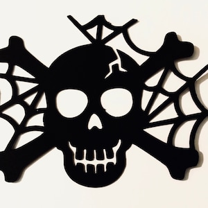 May include: Black silhouette of a skull with crossbones and spiderwebs. Halloween decoration.
