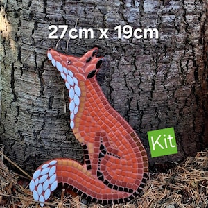 May include: A mosaic fox craft kit measuring 27cm x 19cm. The fox figure is constructed from small orange, white, and black tiles, featuring a white underbelly and tail tip, with a green square label in the corner containing the text Kit.