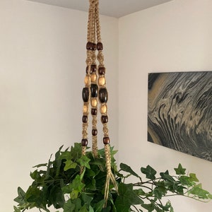 Lång makraméblomhängare, naturlig jute och träpärlor.