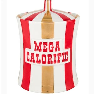 May include: A white ceramic jar with red and gold stripes and a matching lid. The jar has the words "MEGA CALORIFIC" in red lettering. The jar is designed with a circus or carnival theme.