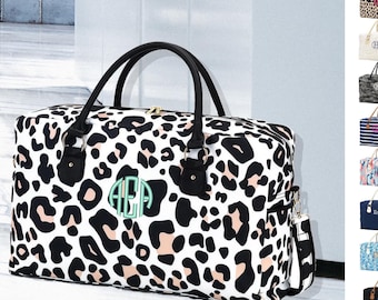 May include: A large leopard print duffel bag with black handles and a detachable shoulder strap. The bag features a light green monogram and gold-colored zipper. Additional bags with various patterns are shown.
