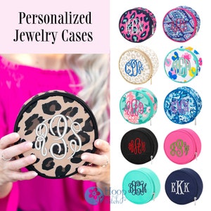 May include: A collection of round, zippered jewelry cases with various patterns and colors. Each case features a personalized monogram in white embroidery. The cases are perfect for storing small items like jewelry, coins, or other trinkets.