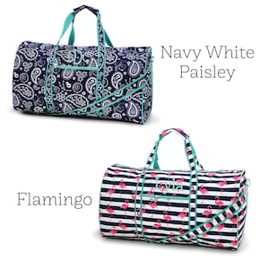 May include: Two duffel bags. One navy blue with white paisley print, teal accents, and monogram. The other bag has a white and navy stripe pattern with pink flamingoes, teal accents, and a monogram. The text "Navy White Paisley" and "Flamingo" are visible.