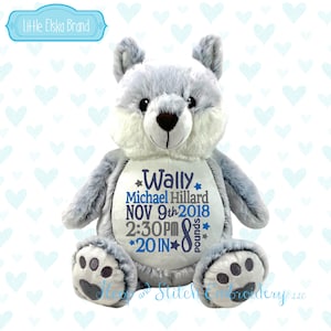 May include: A gray and white plush teddy bear with embroidered details. The bear is personalized with the name "Wally" and the text "Michael Hillard NOV 9th 2018 2:30PM *20 IN* 8 pounds".
