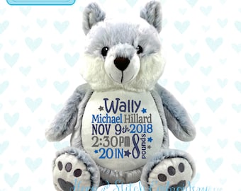 May include: A gray and white plush teddy bear with embroidered details. The bear is personalized with the name "Wally" and the text "Michael Hillard NOV 9th 2018 2:30PM *20 IN* 8 pounds".