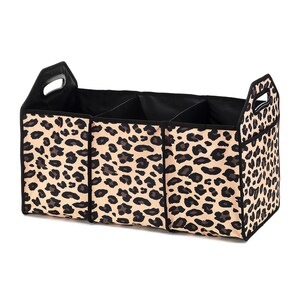 May include: A black and tan leopard print fabric storage organizer with three compartments and a handle. The organizer is designed to fit in the back of a car.