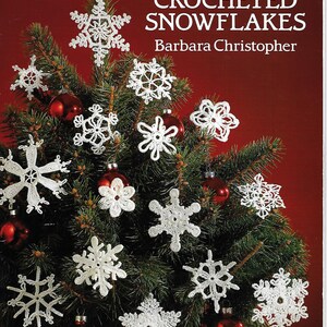 May include: A book cover with the title "60 Crocheted Snowflakes" by Barbara Christopher. The cover features a Christmas tree decorated with crocheted snowflakes.