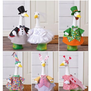 May include: Simplicity pattern S3223 features goose-shaped decorations in various costumes. The geese are dressed as a bride, groom, leprechaun, and Easter bunny. The costumes include hats, dresses, and bow ties. The pattern is designed and printed in the USA.