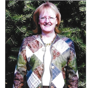 May include: A patchwork jacket with a variety of patterned squares in shades of green, blue, brown, and white. The jacket has a button-up front and is labeled "On Point Jacket" by Downie Designs. Sizes 4-24.