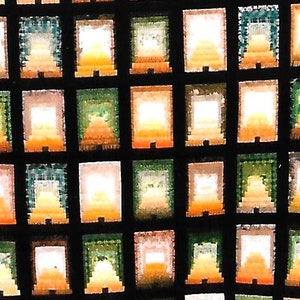 May include: A close-up of a colorful stained glass window with a repeating pattern of small, rectangular panes. The panes are arranged in a grid pattern and are filled with different shades of orange, yellow, green, and blue.