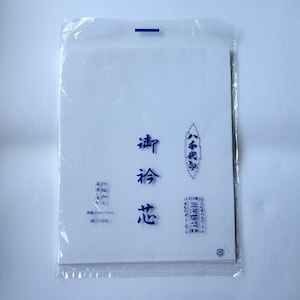 Peut inclure: Un insert en tissu blanc rectangulaire emballé dans un plastique transparent. Le tissu présente des caractères japonais bleu foncé imprimés sur le devant, incluant les spécifications 12cm x 170cm et 100% coton. L'emballage a une bande bleue en haut.