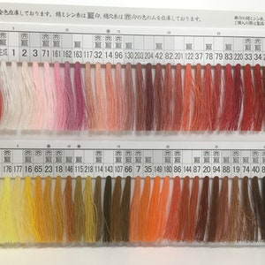 May include: A color chart of embroidery floss with 70 different colors. The floss is arranged in rows and columns, with each color labeled with a number. The colors range from white to black, with shades of red, orange, yellow, green, blue, purple, and brown in between.