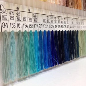 May include: A color chart with rows of thread samples in shades of blue, green, and white. The chart is labeled with numbers, including 84, 153, 101, 154, 155, 172, 85, 173, 175, 25, 46, 49, 50, 75, 47, 48, 138, 91, 199, 21, 102, 22.