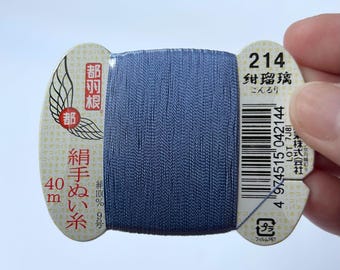 May include: A spool of blue thread with Japanese text and a barcode. The label reads "214" and "紺瑠璃" (Konruri). The thread is 40 meters long.