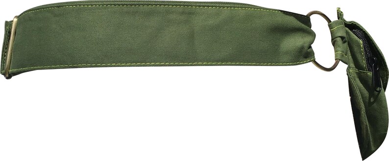 May include: Olive green belt bag with a rectangular main compartment and a small zippered pouch. The bag features a gold-colored metal zipper and a circular metal ring. The bag is made of a durable fabric and is designed to be worn around the waist.