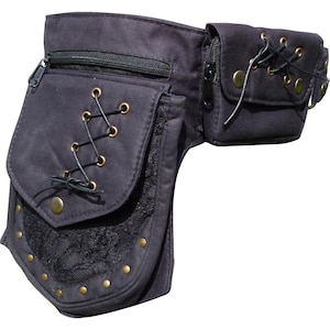 May include: Black utility belt with multiple zippered pockets and a lace-trimmed flap. The belt features decorative grommets and a laced design on the front pockets. The belt is made of a dark fabric.