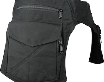 May include: Black hip bag with multiple zippered compartments. The bag features a large front pocket with a flap and a smaller zippered pocket above it. The bag is made of a durable fabric and has a strap for securing it around the waist.