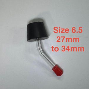 May include: A black rubber stopper with a clear glass tube and a red tip. The text "Size 6.5 27mm to 34mm" is printed in red.