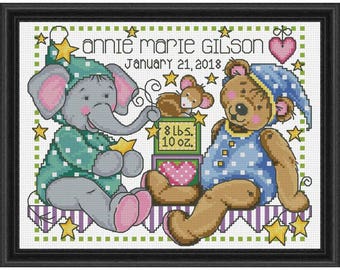 May include: A cross-stitch embroidery design featuring a green elephant and a brown teddy bear wearing pajamas. The design includes stars, hearts, and the text "annie marie gilson January 21, 2018 8 lbs. 10 oz."