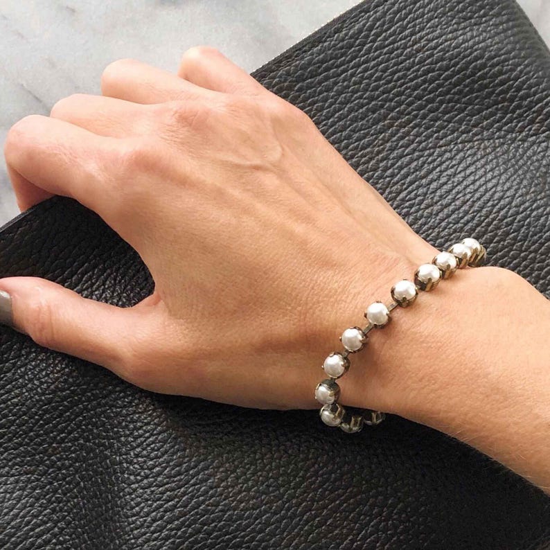Faux pearl tennis bracelet in antique silver cupchain shown on hand.