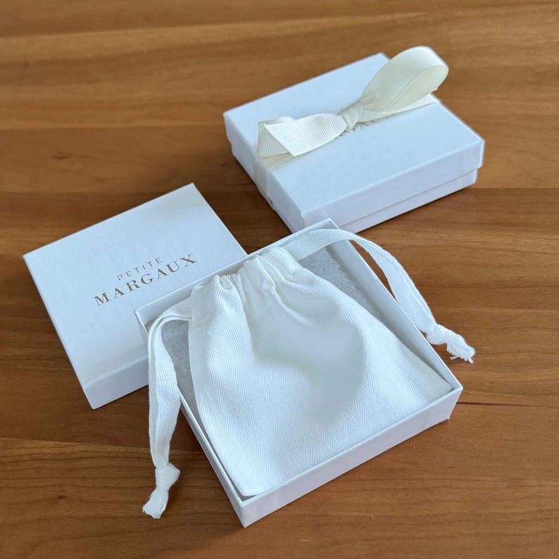 Image of free gift wrapping - branded box, white cotton pouch and grosgrain ribbon.