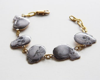 Pulsera de resina brillante en blanco y negro con calavera sobre metal de latón