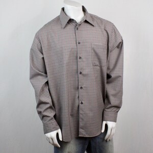 May include: A long-sleeved button-down shirt with a brown and blue checkered pattern. The shirt has a classic collar, a chest pocket, and buttoned cuffs. The shirt is displayed on a mannequin.