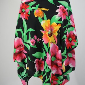 May include: A black triangular scarf with a floral print featuring pink, red, yellow, and green flowers on a black background.