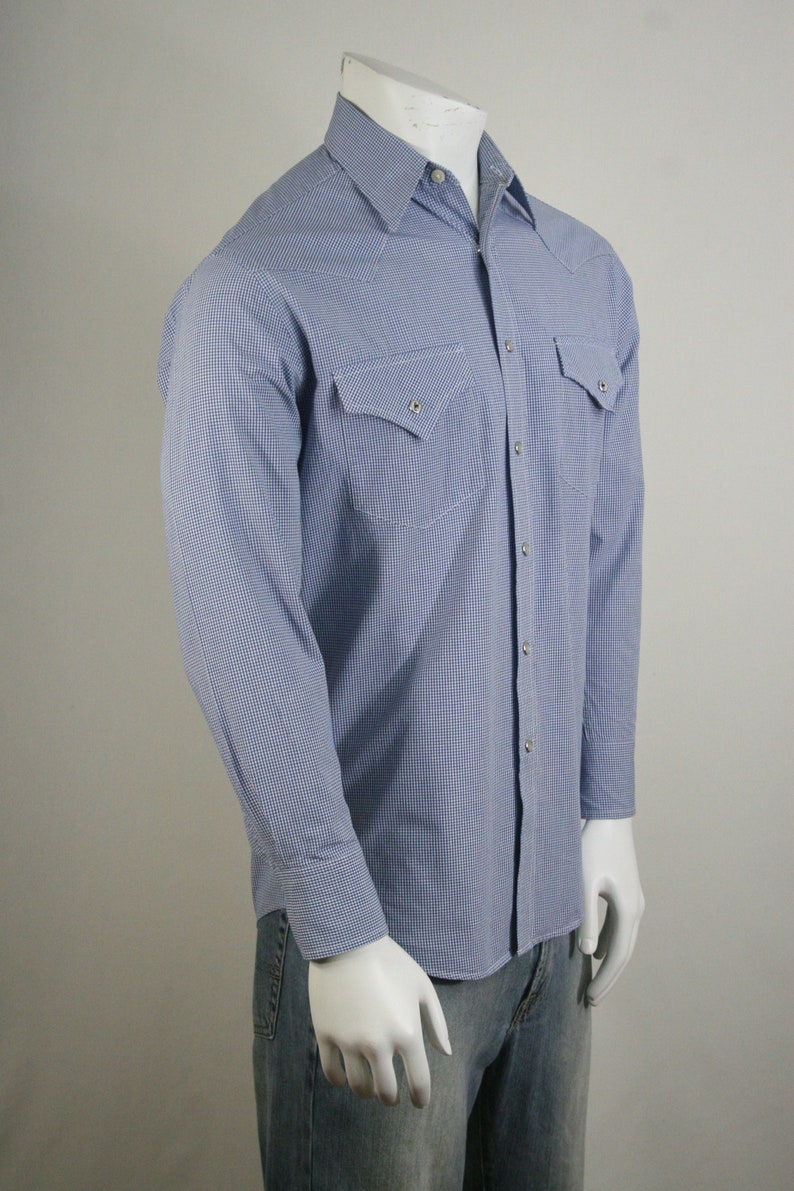 May include: A blue and white gingham long-sleeve shirt with a button-down collar and two chest pockets.