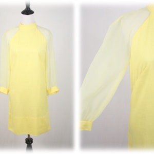 May include: A yellow dress with sheer sleeves. The dress has a high neck and a simple design.