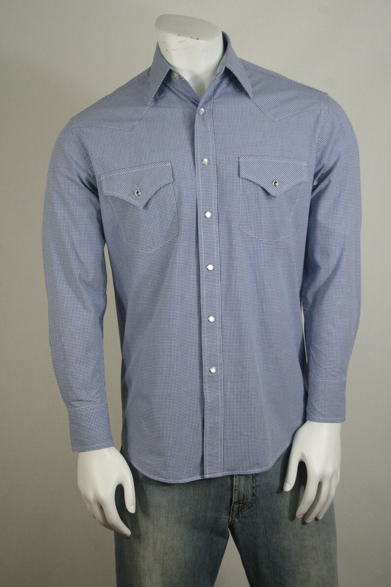 May include: A blue and white gingham long-sleeve shirt with a button-down collar and two chest pockets.