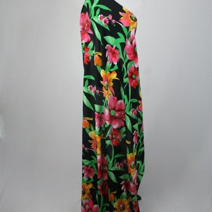 May include: Black fabric with a large floral print featuring pink, red, yellow, and green flowers. The fabric is draped over a mannequin.
