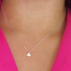 May include: A silver chain necklace with a small heart pendant.