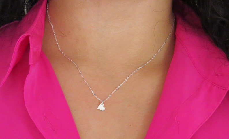 May include: A silver chain necklace with a small heart pendant.