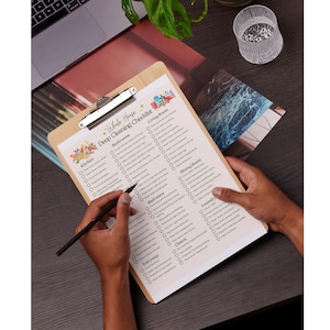 May include: A checklist on a clipboard with a wooden frame. The checklist is titled "Whole House Deep Cleaning Checklist" and includes categories for different rooms, such as kitchen, bathrooms, bedrooms, living room, dining room, laundry, closets, and entryway. Each category has a list of cleaning tasks to complete.