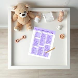 May include: A checklist for newborn baby essentials, printed on a light purple sheet of paper with a purple footprint design. The checklist is divided into categories such as clothing, health & safety, bath & body, and feeding. The checklist is on a white changing table with a teddy bear, a bottle, and other baby items.