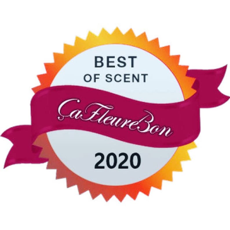 Może przedstawiać: Biała i pomarańczowa pieczęć nagrody z czerwoną wstążką. Pieczęć zawiera napis "Best of Scent" i "Ca Fleure Bon 2020".
