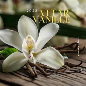 May include: A white orchid flower with a red center sits on a wooden surface with vanilla beans. The text "2022 ATTAR VANILLE RISING PHOENIX" is displayed above the flower.