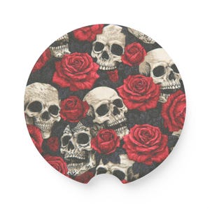 May include: A circular car coaster featuring a repeating pattern of off-white human skulls and vibrant red roses set against a dark black background. The coaster has a small semi-circular notch cut out from the bottom edge for easy removal.