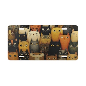 May include: A rectangular license plate featuring a whimsical illustration of numerous stylized cats. The cats have various colors and patterns, including black, orange, yellow, and gray, with large, expressive eyes. The design is a repeating pattern.